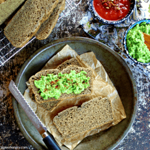 overhed shot of slices of chickpea flour flax bread with a green pea spread