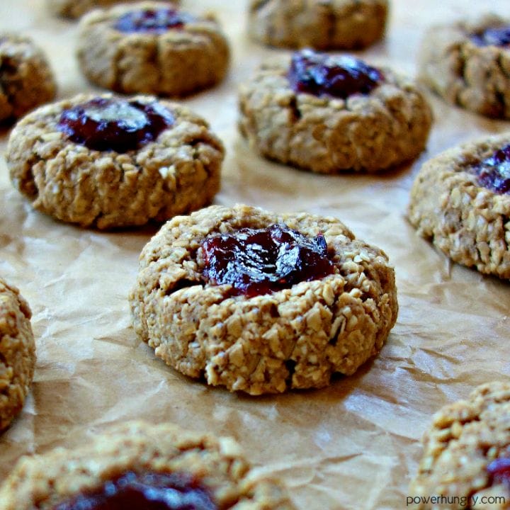 baked vegan oat thumbprints on a parchment paper-lined baking sheet