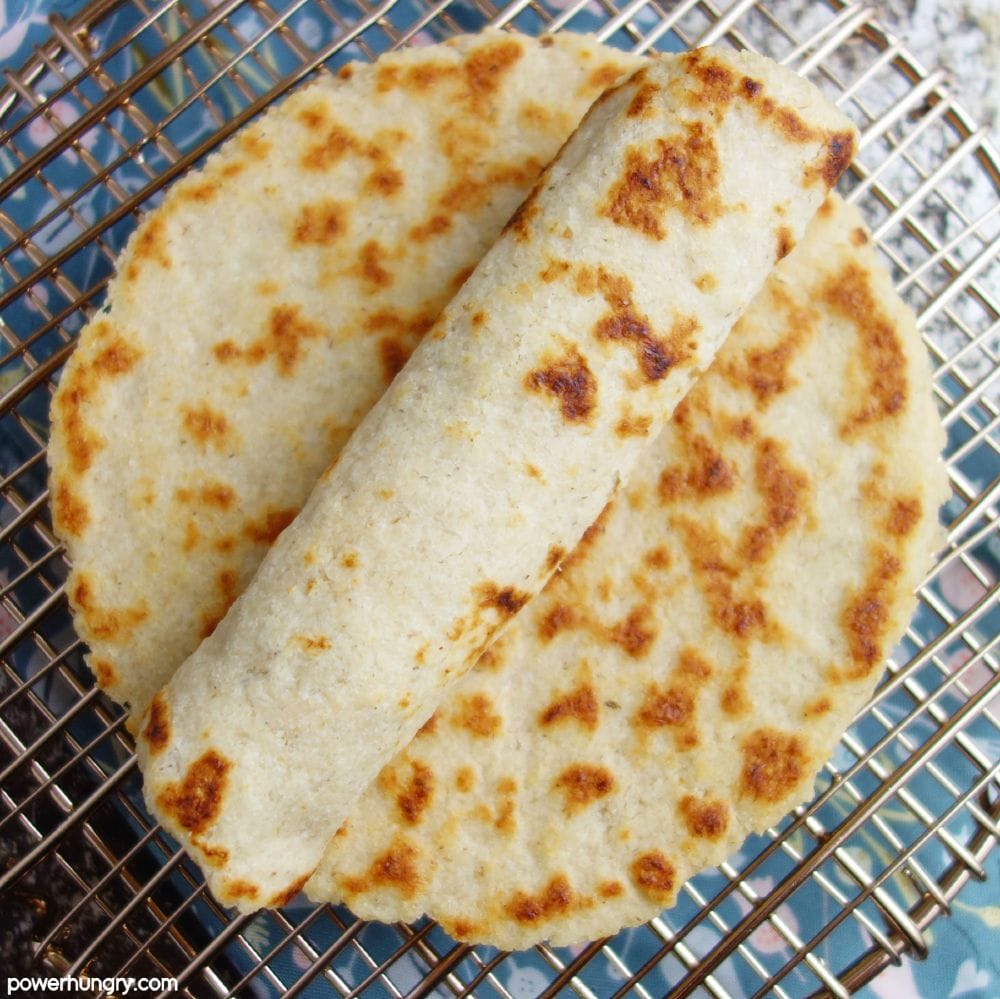 rolled almond flour torilla on top of a stack of tortillas