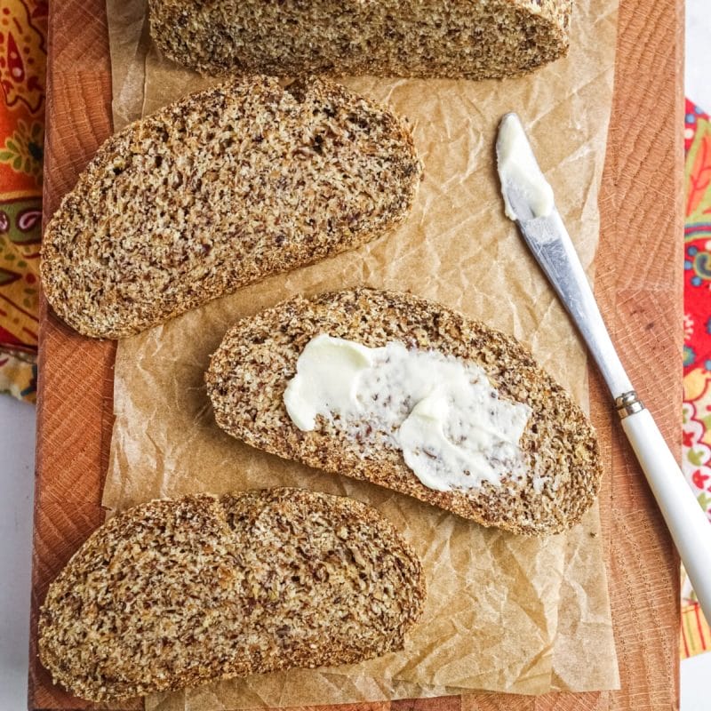 slices of coconut flour flax bread on a wood cutting board