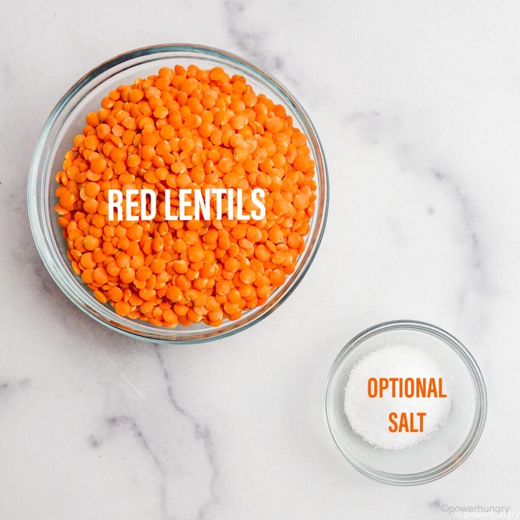 over head shot of two glass bowls, one filled with red lentils and one with salt