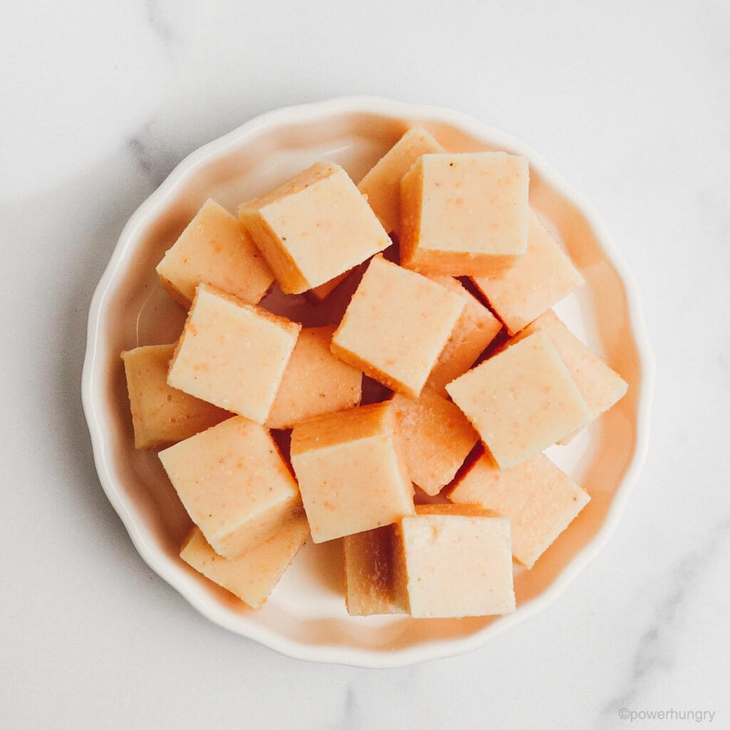 white dish filled with cubes of red lentil tofu