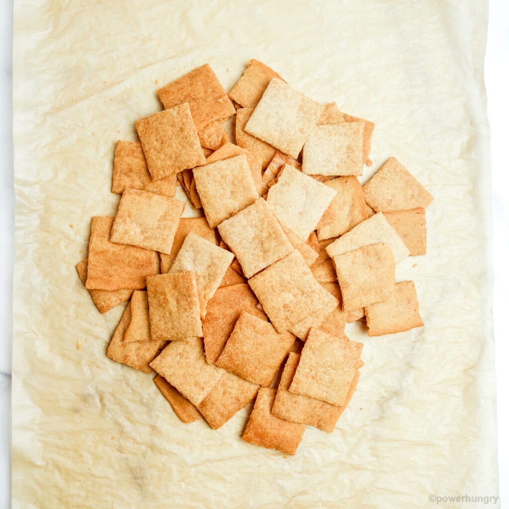 baked cassava flour crackers on a parchment lined baking sheet.
