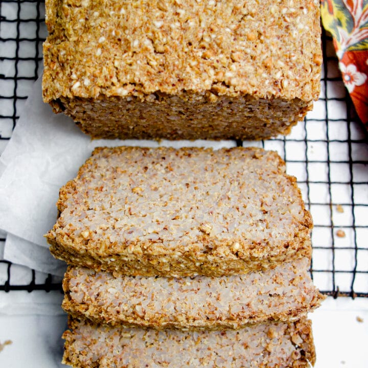 loaf of cinnamon whole buckwheat groat bread on a dark cooling rack