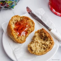 an easy 2-ingredient fluffy flax roll, split, on a white plate, spread with jam