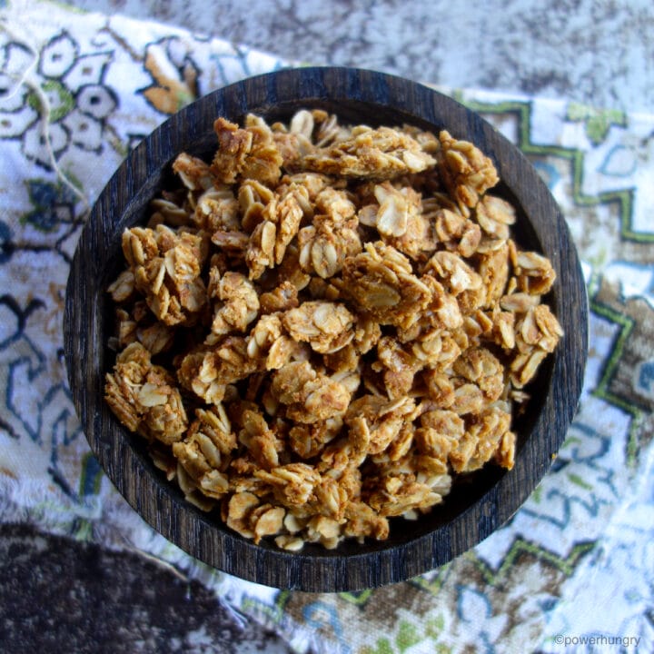 a wooden bowl filled with peanut butter granola