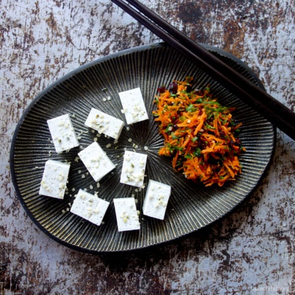 easy 2-ingredient hemp tofu on a metal plate, accompanied by carrot salad