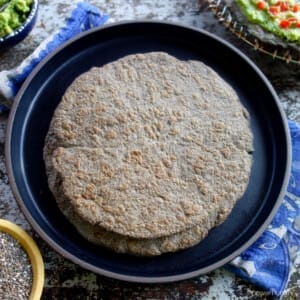 a stack of chia flatbreads on a black plate