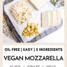 a grey marble platter topped with oil-free vegan mozzarella that is sliced and grated