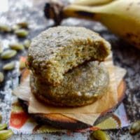 pumpkin seed banana cookies stacked on a wooden disk